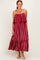 woman wearing a red and white striped maxi dress with ruffled sleeves and a flowing skirt