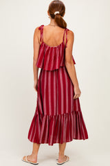 woman wearing a red striped maxi dress with ruffled straps and a tiered hem, shown from the back