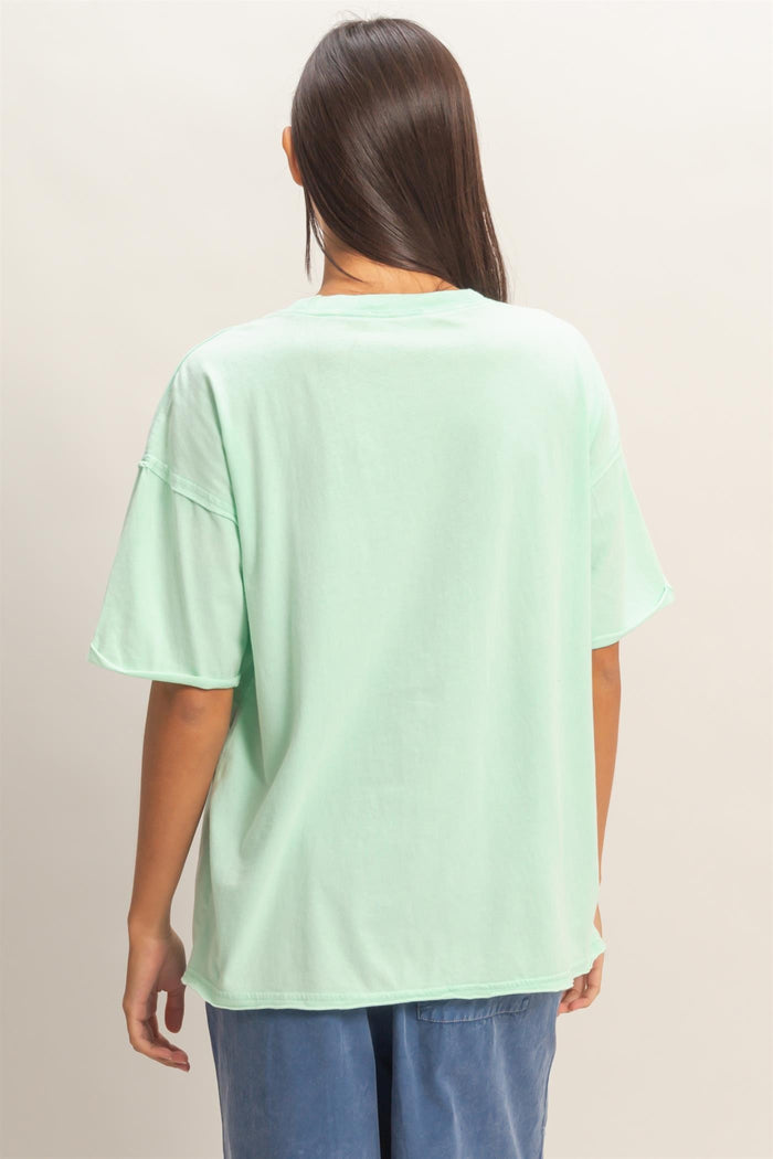 woman wearing a mint green oversized t-shirt with a relaxed fit and short sleeves