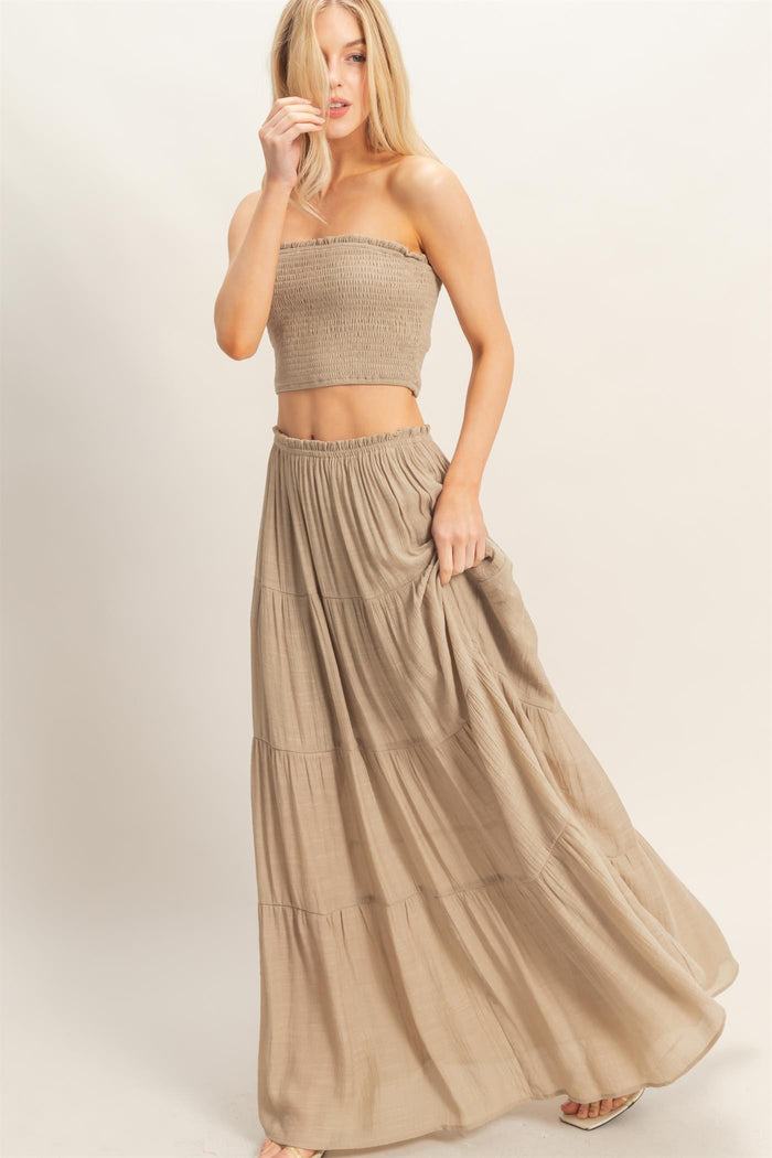 woman wearing a beige smocked crop top and matching tiered maxi skirt