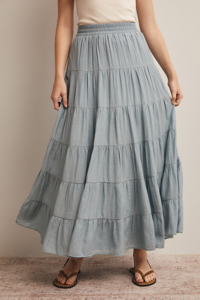 woman wearing a light blue tiered maxi skirt with an elastic waist and sandals