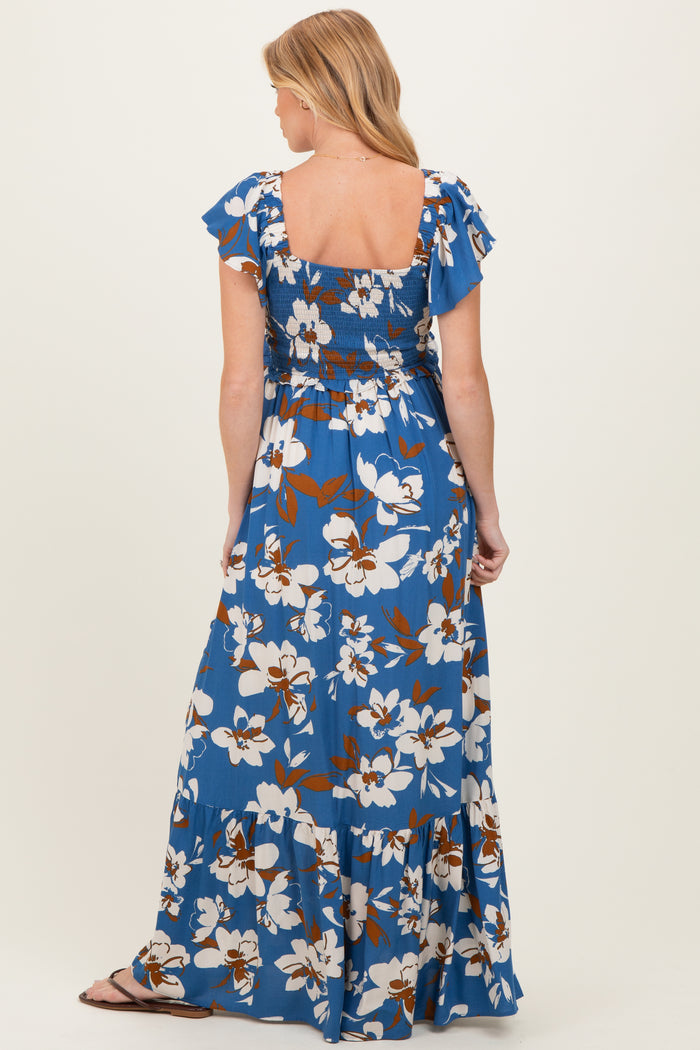 woman wearing a blue floral maternity maxi dress with ruffled sleeves and smocked back detail