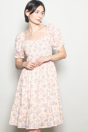 woman wearing a pastel floral midi dress with short puff sleeves and a smocked bodice