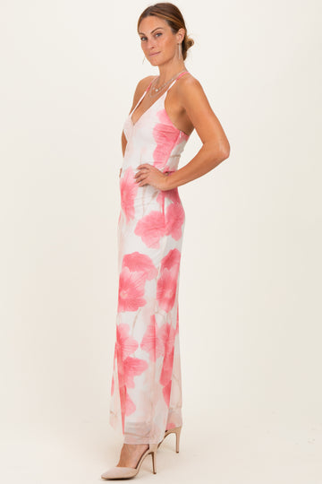woman wearing a floral maxi dress with pink flowers and a plunging neckline, styled with nude heels