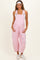 woman wearing a pink striped maternity overall with adjustable straps and front pockets