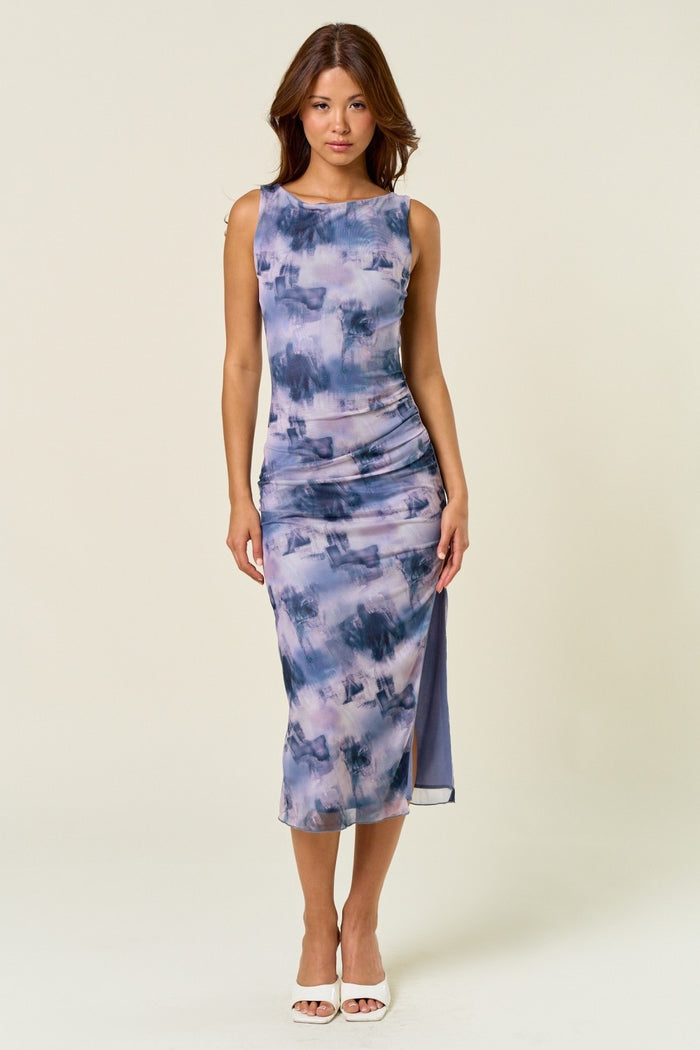woman wearing a purple tie-dye midi dress with a scoop neckline and side slit
