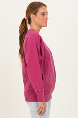 woman wearing a bright pink long sleeve sweatshirt with a relaxed fit and side pockets