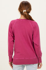 woman wearing a pink sweatshirt with a relaxed fit and ribbed hem, viewed from the back