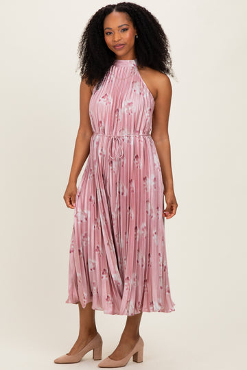 woman wearing a pink floral pleated halter dress with a tie waist and knee-length skirt