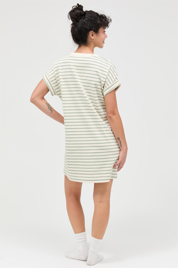 woman wearing a striped oversized t-shirt dress with rolled sleeves, facing away from the camera