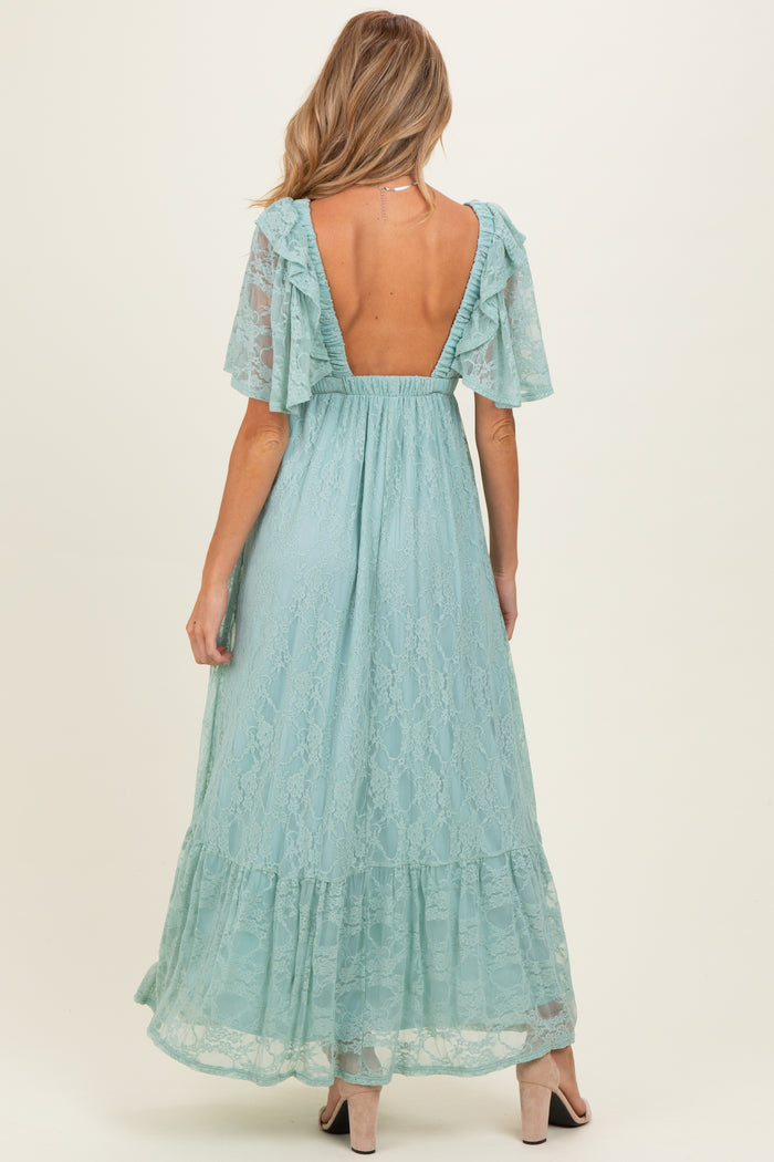 woman wearing a light blue lace maternity maxi dress with flutter sleeves and open back, showing a baby bump