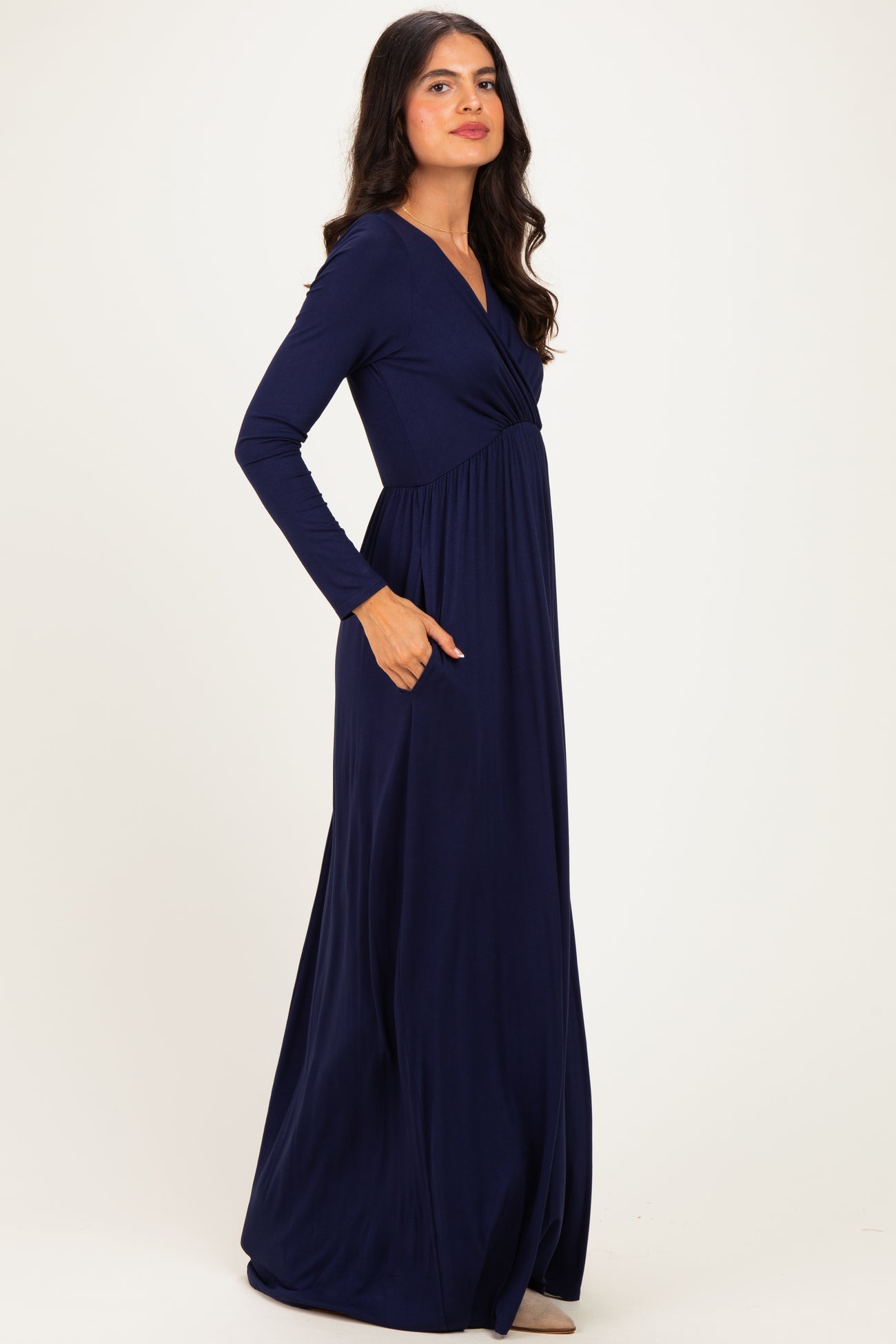woman wearing a long sleeve navy blue maxi dress with a wrap design and side pockets