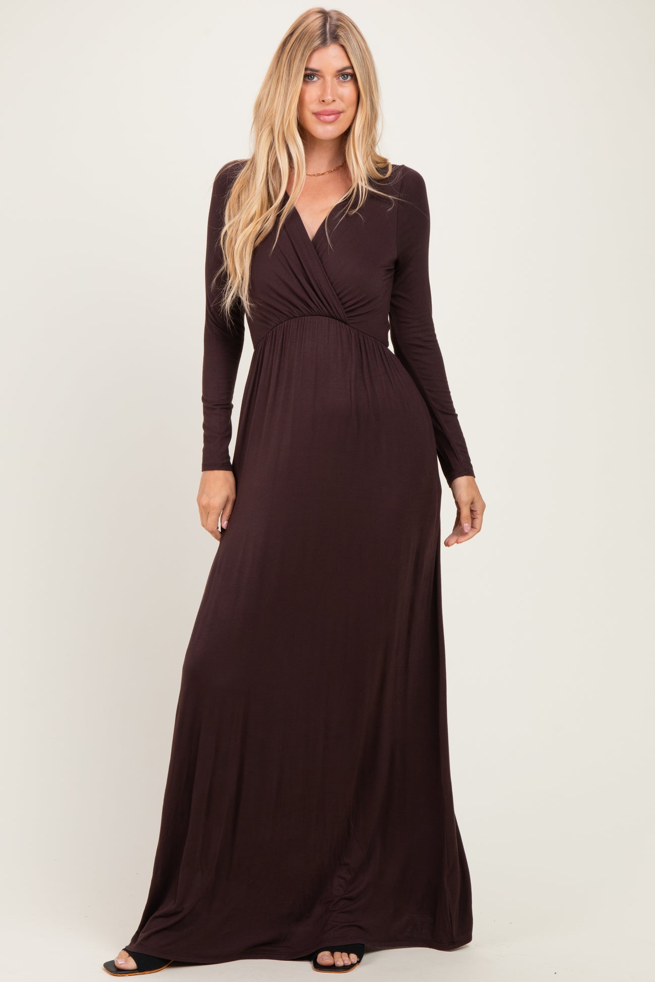 woman wearing a dark burgundy long sleeve maxi dress with a deep v-neck and wrap detail