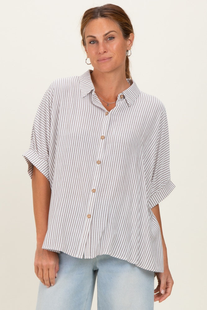 woman wearing a striped button-up shirt with short sleeves and relaxed fit, styled with light blue jeans