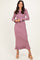 woman wearing a long sleeve ribbed pink dress with ruffled hem and button details on the sleeves