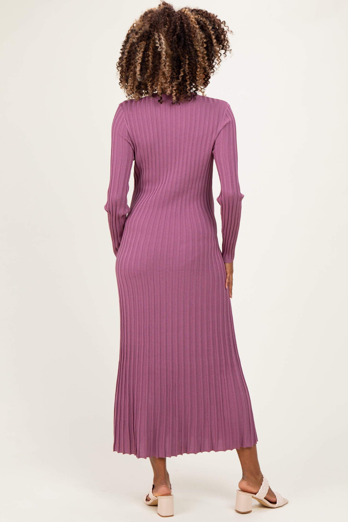 woman wearing a long purple ribbed maternity dress, view from the back, fitted style with long sleeves