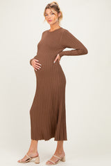 woman wearing a brown ribbed long sleeve maternity dress and posing with her baby bump