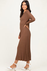 woman wearing a chocolate brown long sleeve ribbed midi dress and white high-heeled sandals, smiling sideways