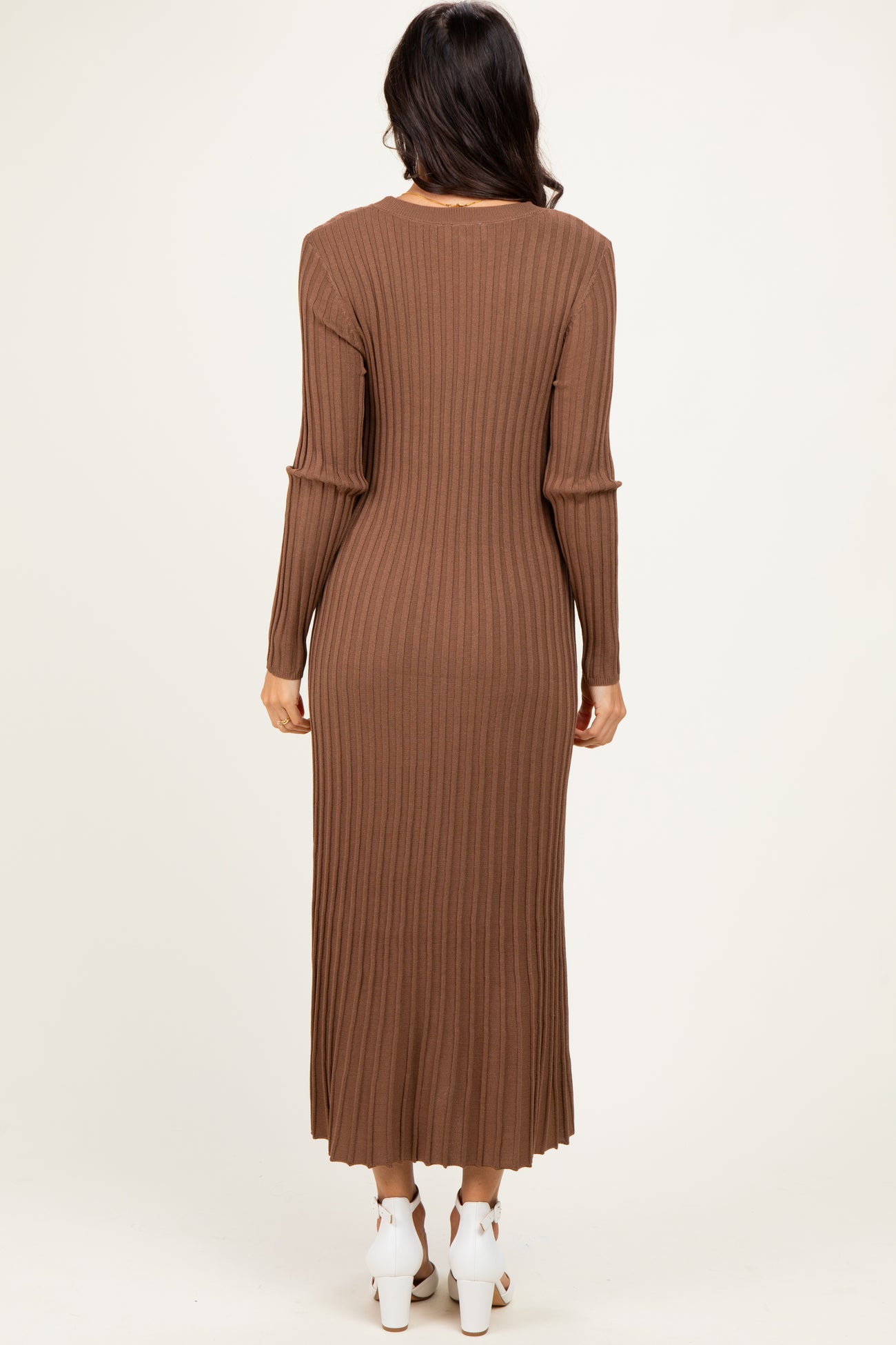 woman wearing a long brown ribbed knit dress with long sleeves, viewed from the back