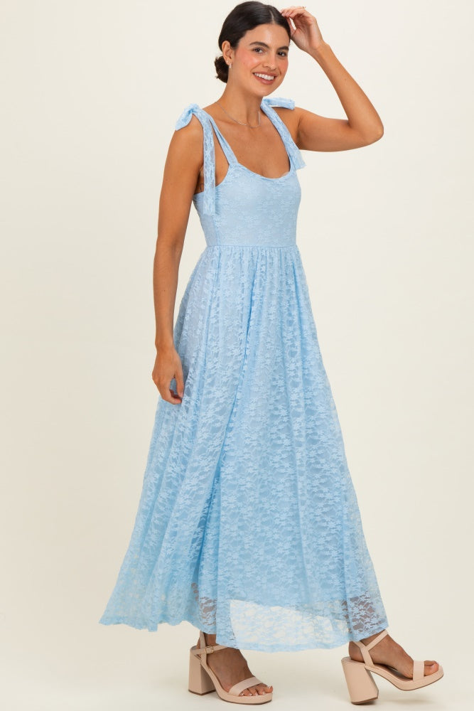 woman wearing a light blue lace maxi dress with shoulder ties and a flowy skirt