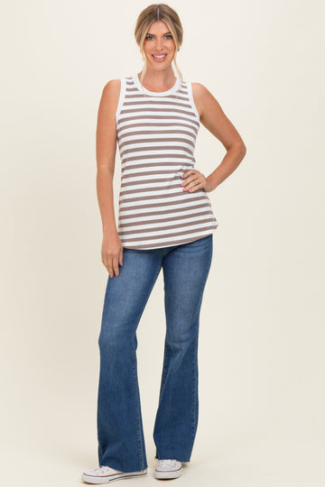 woman wearing a brown and white striped sleeveless top with blue flared jeans