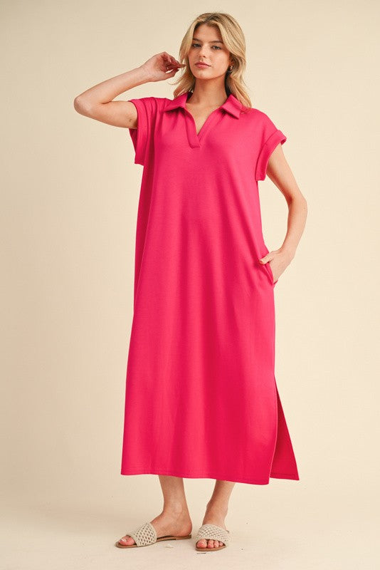 woman wearing a vibrant pink short sleeve polo dress with side pockets and a high slit