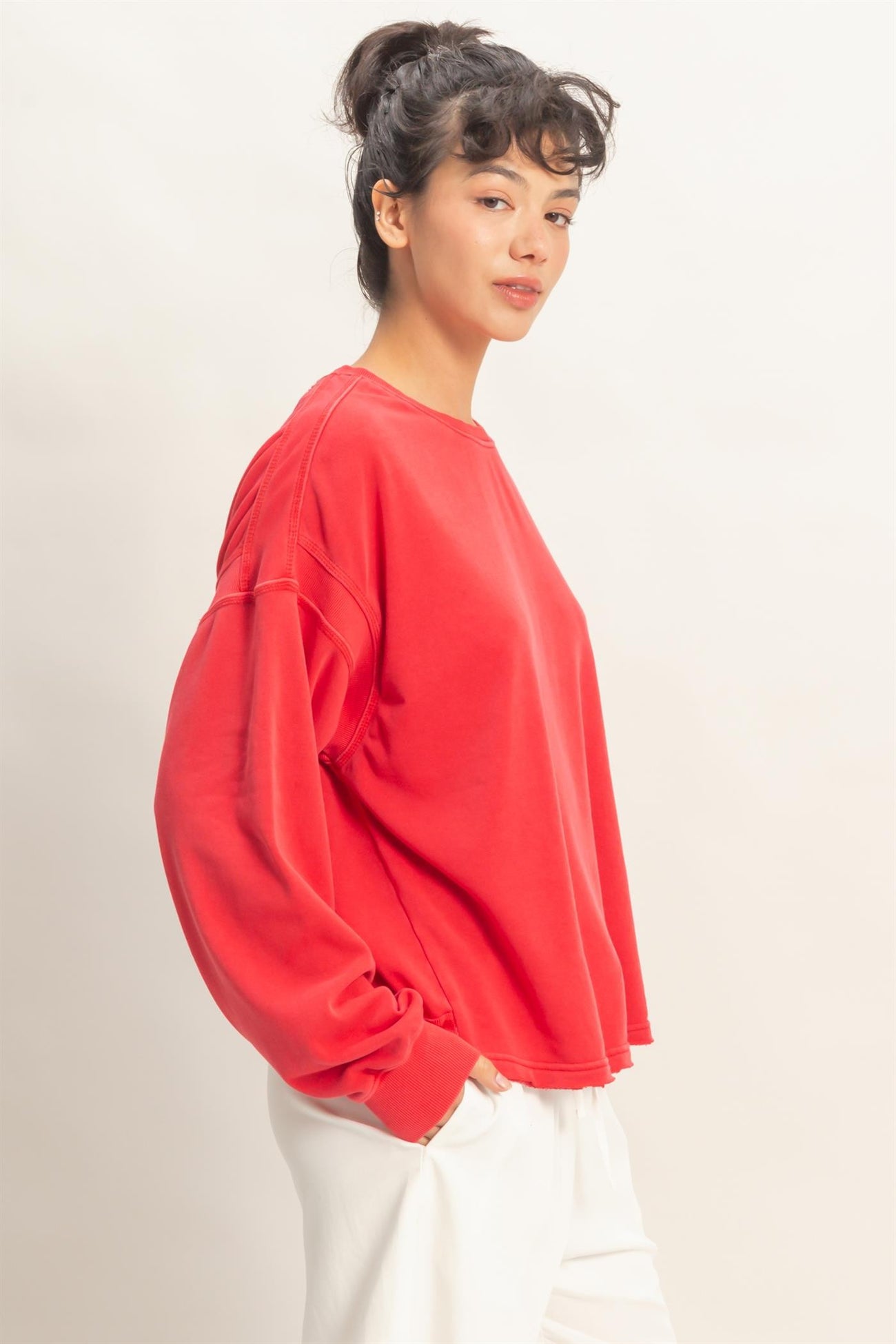 woman wearing a red oversized sweatshirt with dropped shoulders and long sleeves