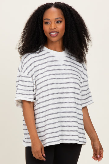 woman wearing a white and gray striped oversized short sleeve top with a relaxed fit