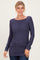 woman wearing a dark purple long sleeve top with a scoop neckline and rouched side detail