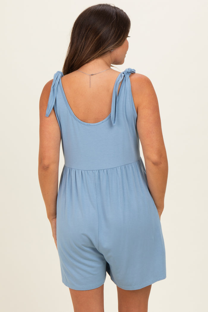 woman wearing a light blue maternity romper with tie shoulder straps and an empire waist