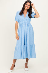 woman wearing a light blue puff sleeve maxi dress with a tiered skirt and v-neckline