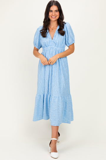 woman wearing a light blue midi dress with puff sleeves and a tiered hem