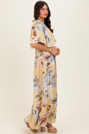 woman wearing a yellow floral maxi dress with ruffled sleeves and a relaxed fit, standing sideways