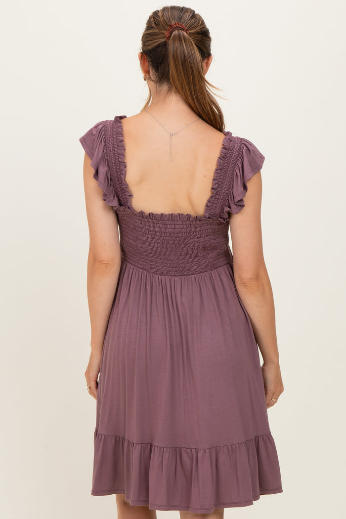 woman wearing a lavender maternity dress with a smocked bodice and ruffled sleeves, showing the back view