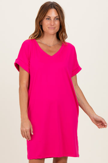 woman wearing a bright pink short sleeve v-neck dress with rolled sleeves