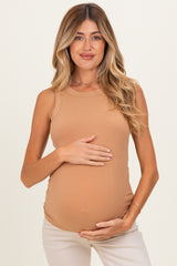 woman wearing a tan ribbed maternity tank top and holding her baby bump