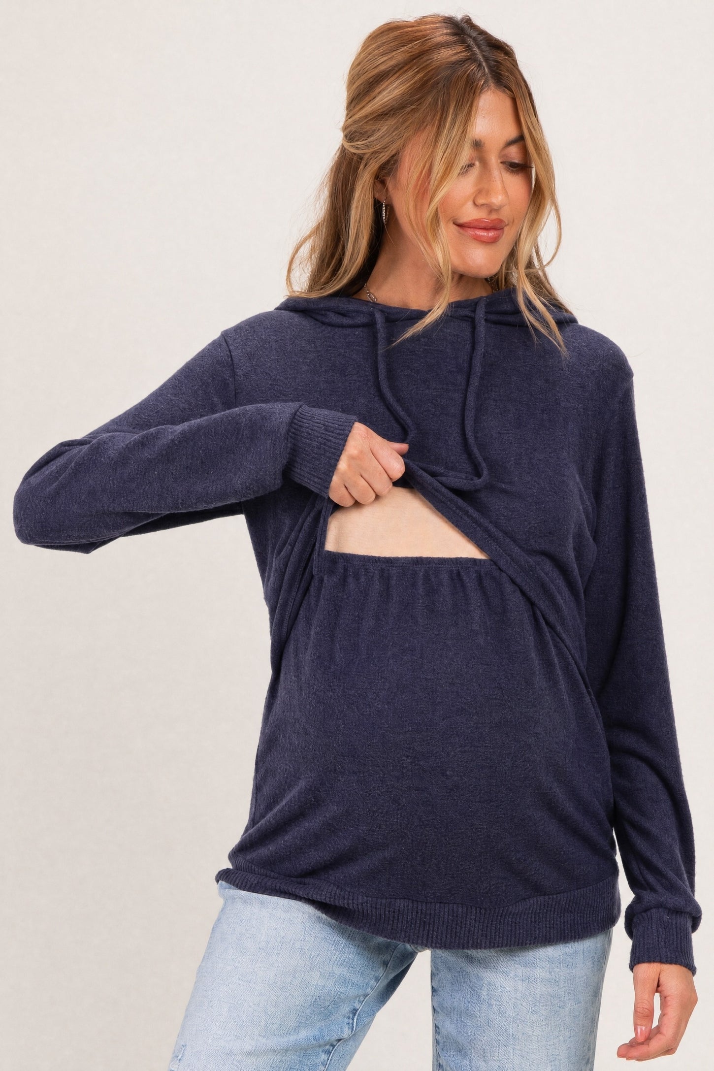 woman wearing a navy blue maternity hoodie with a front opening, showing her baby bump