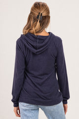 woman wearing a navy blue maternity hoodie with a drawstring hood and long sleeves, showing a relaxed fit from the back