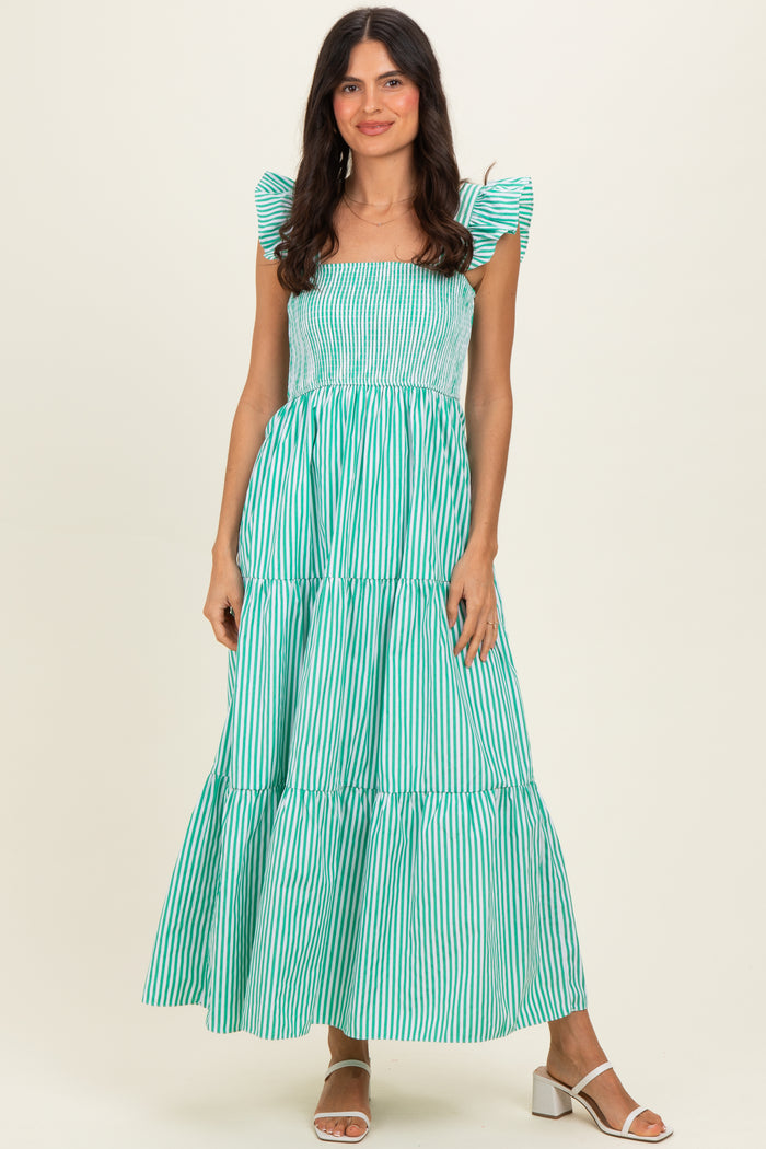 woman wearing a green and white striped maxi dress with puff sleeves and a tiered skirt