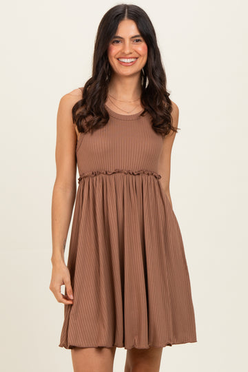 woman wearing a brown sleeveless ribbed dress with a cinched waist and flared skirt