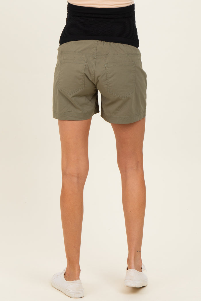 woman wearing olive green maternity shorts with a black waistband, viewed from the back