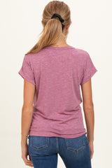 woman wearing a pink short sleeve maternity top, seen from the back, paired with blue jeans