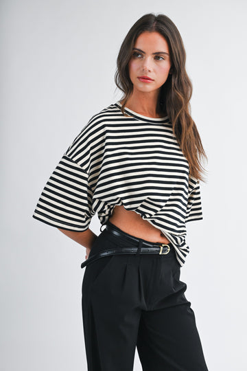 woman wearing a black and white striped oversized t-shirt with high-waisted black trousers