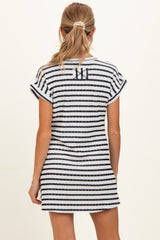 woman wearing a black and white striped maternity dress with short sleeves, showing the back view