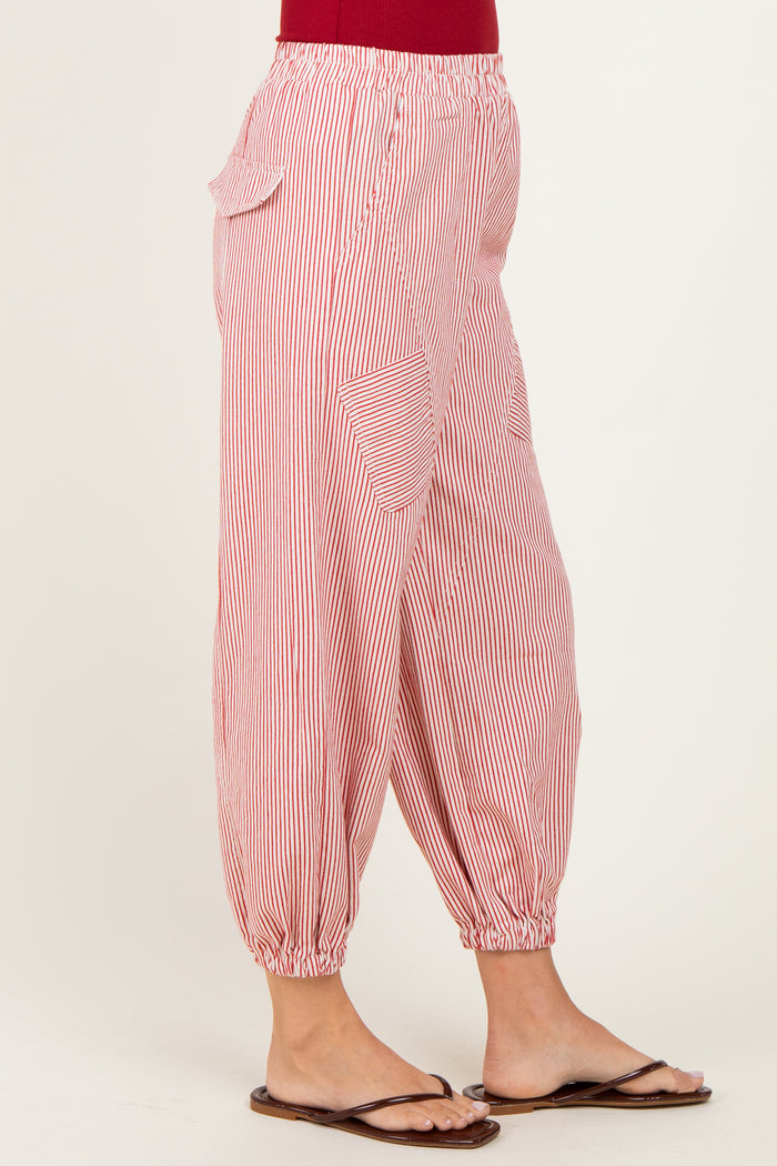 woman wearing red and white striped elastic waist pants with side pockets and gathered cuffs