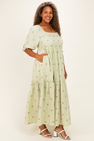 woman wearing a light green floral print maxi dress with puff sleeves and pockets