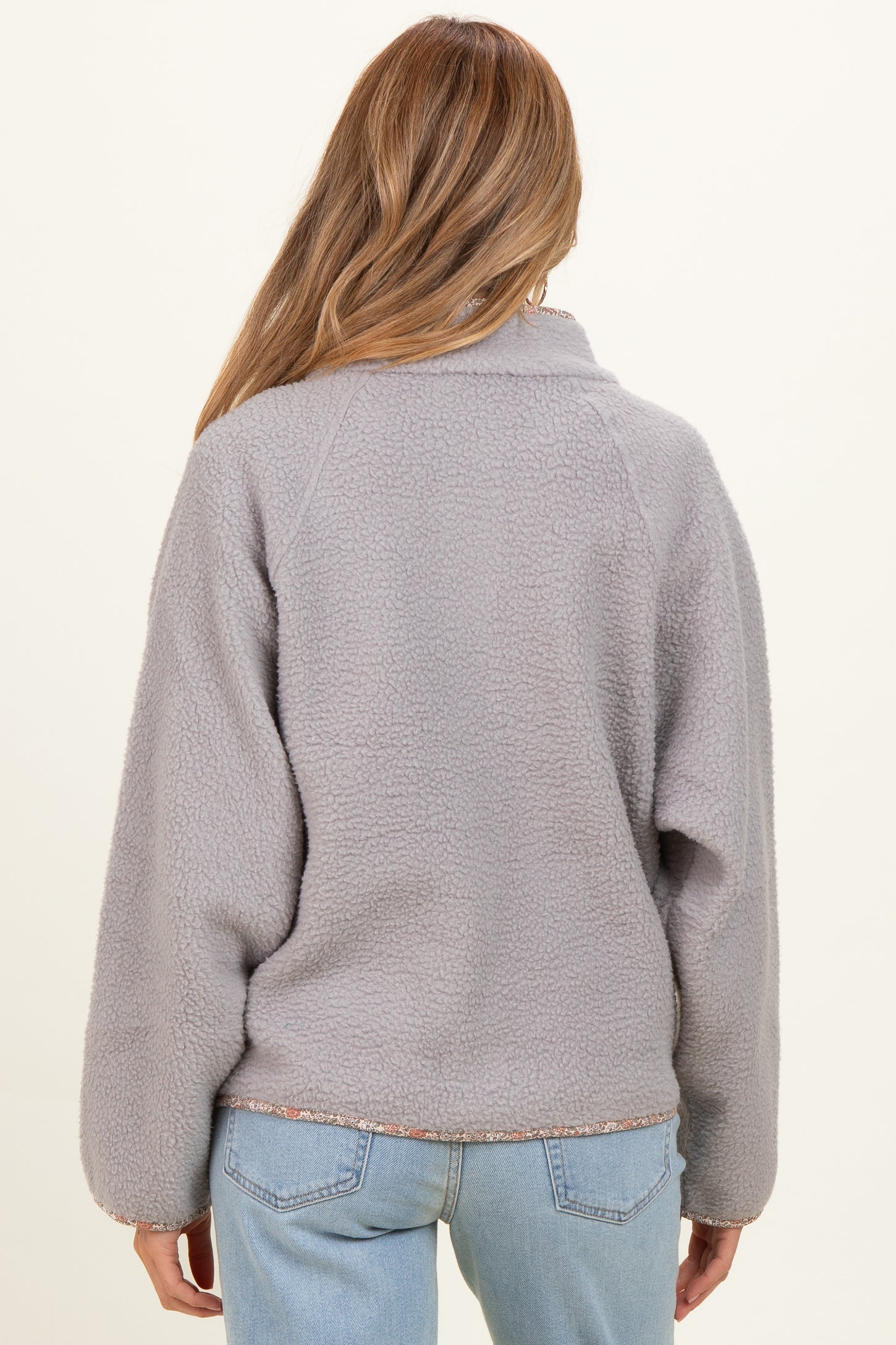 woman wearing a gray maternity fleece pullover with a relaxed fit and textured fabric, view from the back