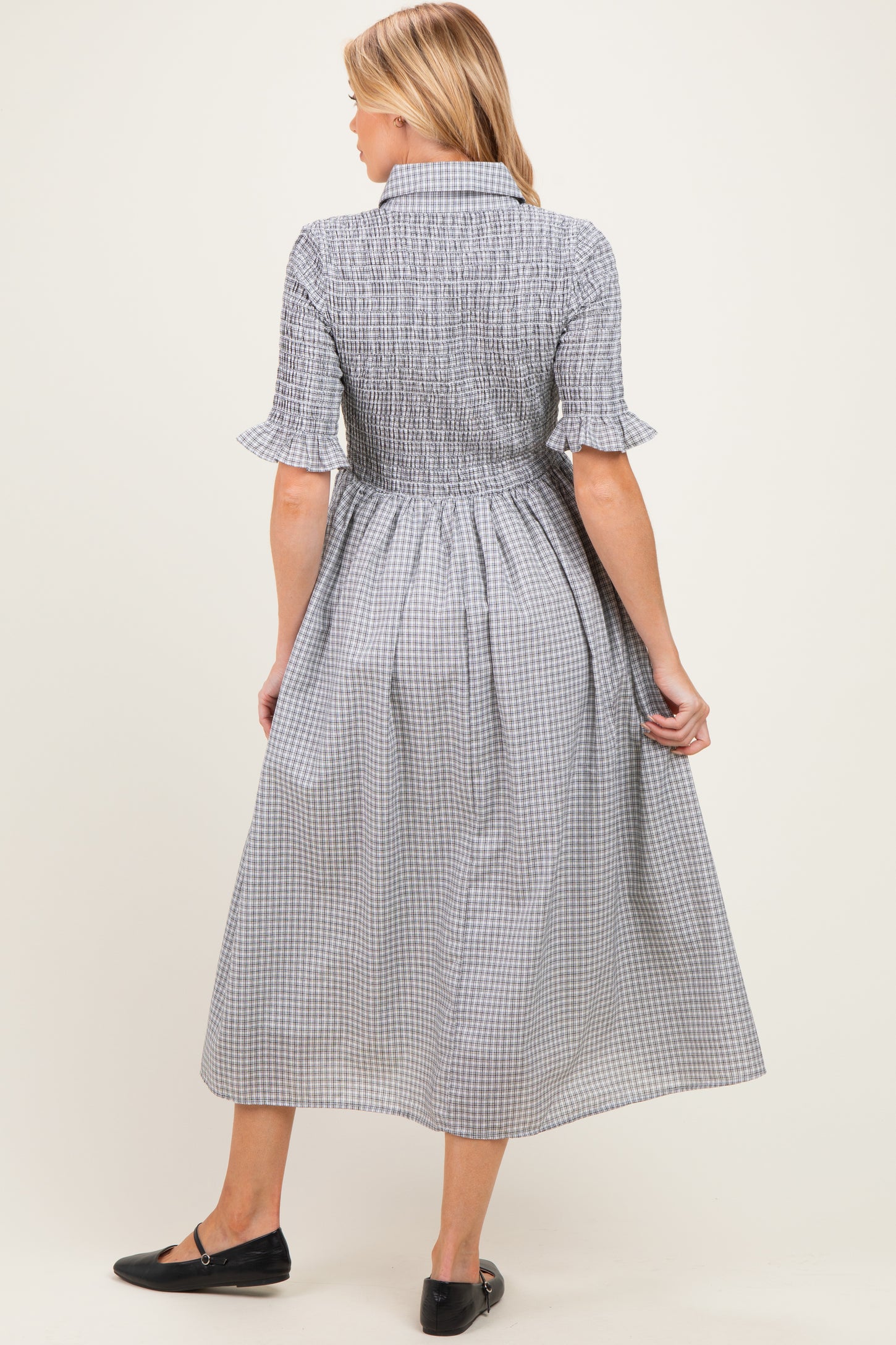 woman wearing a checkered midi maternity dress with short sleeves and a cinched waist from the back