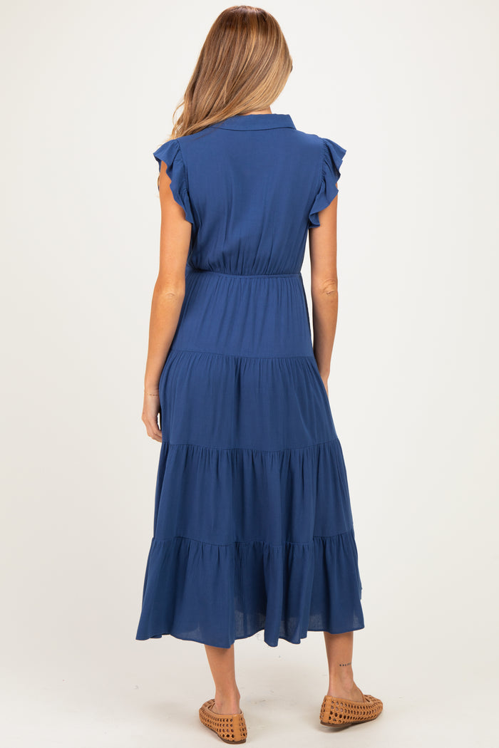 woman wearing a navy blue tiered midi maternity dress with short ruffled sleeves, showing the back view