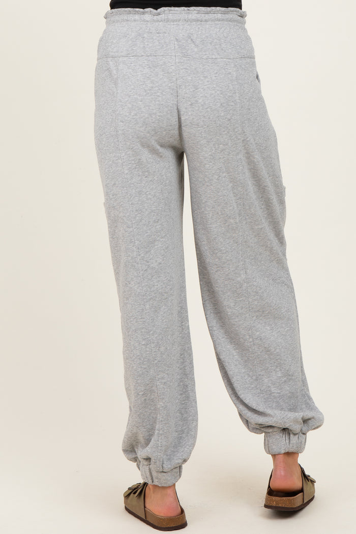 woman wearing gray maternity pants with elastic cuffs and side pockets, shown from the back